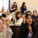 Students hold up game pieces